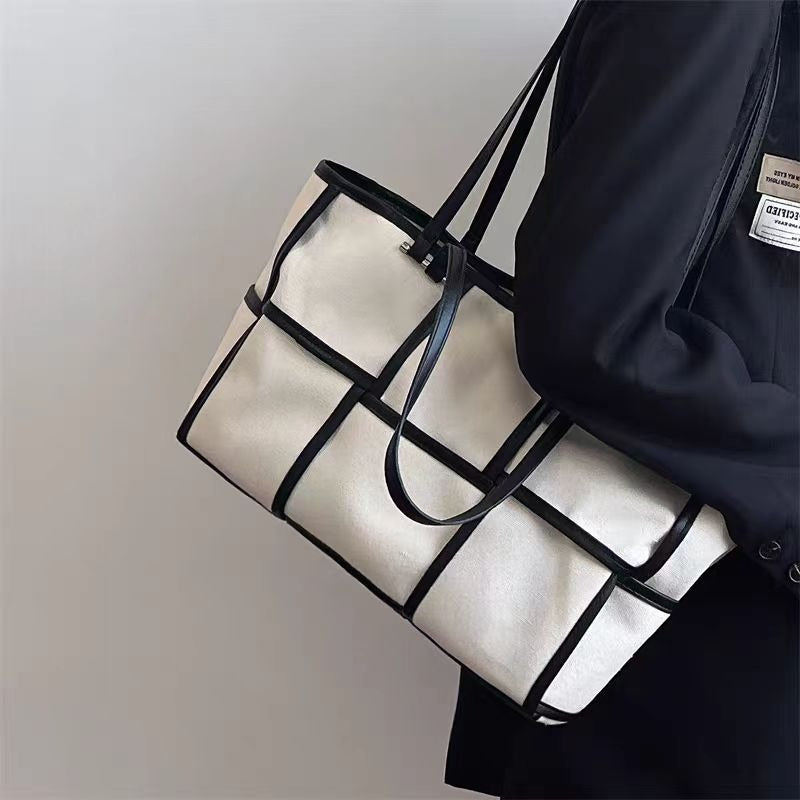 Close up side view of the Black Grid Canvas Tote Bag featuring a white windowpane pattern on durable black fabric.